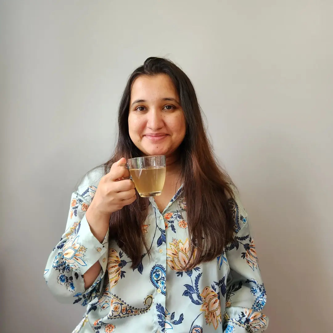 A lady tasting tea and smiling