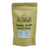 Thumbnail for A brown kraft paper resealable pouch of Nepal Hills Floral White Tea. The packaging features a gold pagoda illustration, the brand name 'Nepal Hills,' and labels in English and French indicating a net weight of 25 grams.