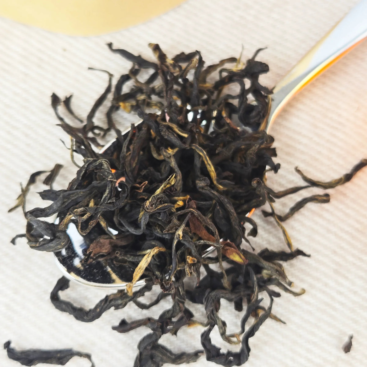 Close-up of dried black tea leaves on a white cloth